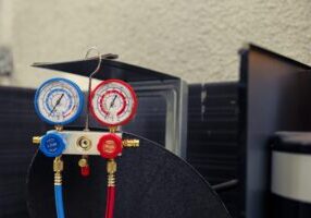 Close up of manifold gauges used for checking air conditioner refrigerant in need of maintenance. Set of barometer high or low freon levels benchmarking hvac system component